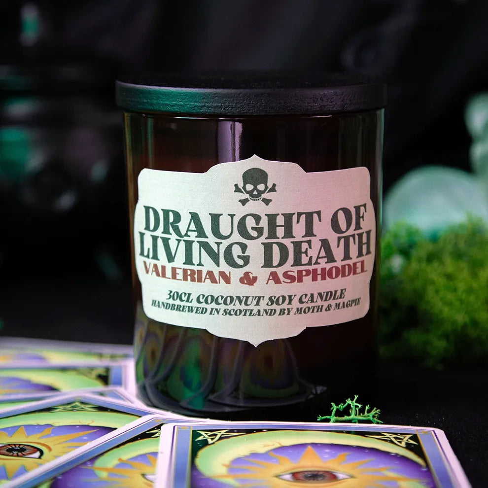 Candle labeled 'Draught of Living Death' with a mystical design on a dark background