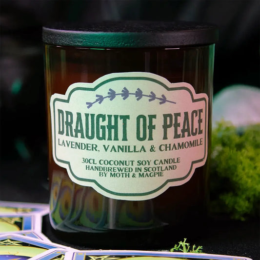 Candle labeled 'Draught of Peace' with a blurred natural background