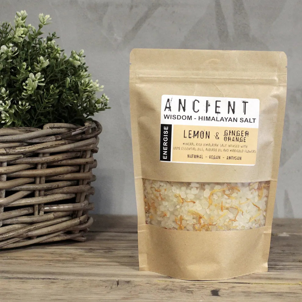 Packaged lemon and ginger Himalayan bath salt - energise blend on a wooden surface with a plant in the background