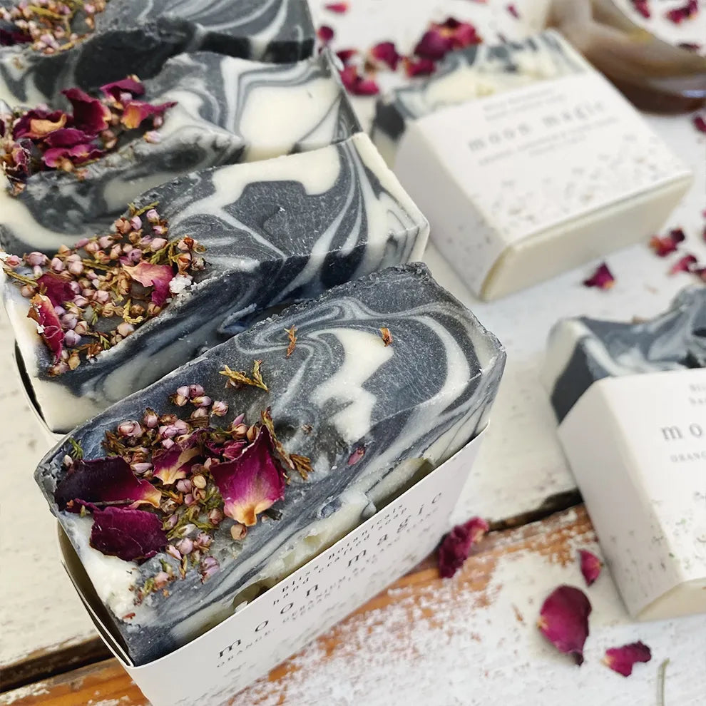 Marble-patterned luxury moon magic soap bars with dried flowers on a rustic wooden surface
