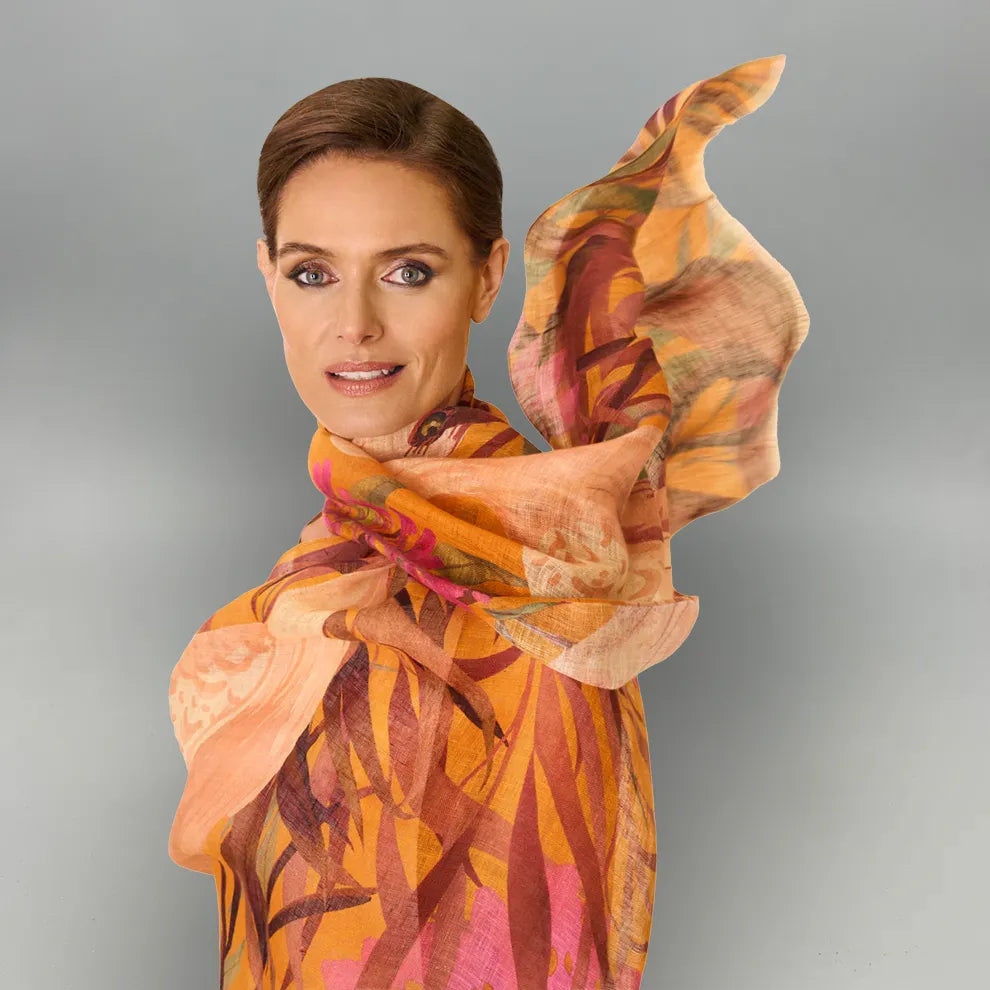 Woman wearing a colorful oriental crane scarf with a gray background