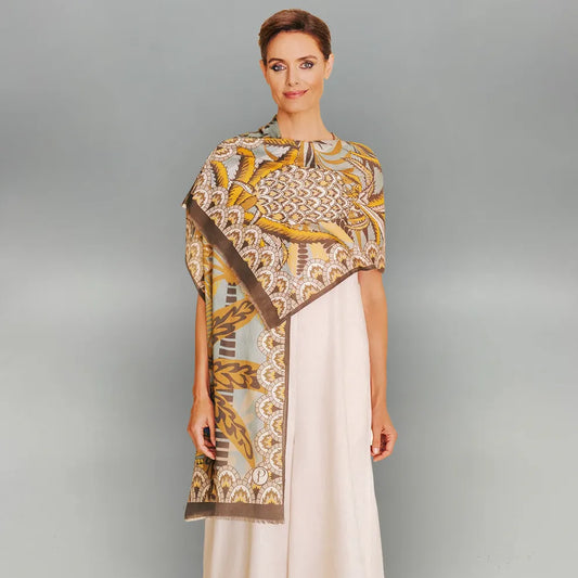 Woman wearing a patterned palms scarf over a plain dress on a gray background